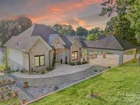Beautiful brick home featuring a covered carport, lush landscaping, and a charming walkway at 445 Sundown Rd, Mooresville, NC 28117