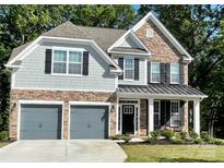 Charming two-story home with a stone and shingle facade, dark shutters, and a welcoming front porch at 5005 Blue Serenity Ct, Denver, NC 28037