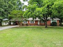 Charming brick home features a lush lawn, mature trees, and inviting curb appeal at 5628 White Store Rd, Wingate, NC 28174
