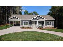 Charming single-story home with a covered porch and carport, showcasing modern design and landscaping at 6386 Cathedral Dr, Granite Falls, NC 28601