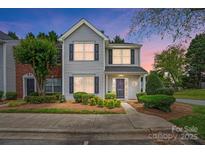 Charming two-story home with gray siding, black shutters, and a well-manicured front yard at 7671 Bluff Point Ln, Denver, NC 28037