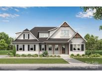 Charming two-story home with a covered front porch, black shutters, and lush landscaping at 770 Highway 274 Rd, Clover, SC 29710