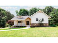 Inviting exterior showcasing a charming home with a covered porch and beautifully landscaped lawn at 8340 Brief Rd, Mint Hill, NC 28227