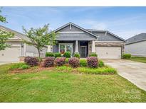 Charming single-story home with a well-manicured lawn and flower beds, showcasing lovely curb appeal at 9525 Festival Way, Charlotte, NC 28215