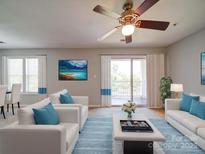 Bright living room features a ceiling fan, plush rug and access to outdoor balcony with natural light at 1023 Triece Ln, Charlotte, NC 28215