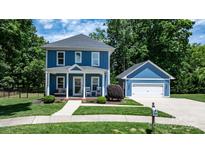 Charming blue two-story home with white trim, covered front porch, and detached garage in a lush, green setting at 1067 33Rd Avenue Ne Loop, Hickory, NC 28601