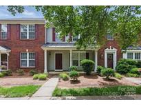 Charming townhouse with brick and siding, complemented by well-maintained landscaping and a inviting front porch at 12350 Swan Wings Pl, Huntersville, NC 28078