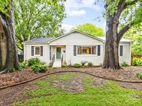 Charming single-story home with a welcoming entrance and beautifully landscaped front yard at 1723 Woodland Dr, Charlotte, NC 28205