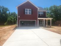 New two story home with a red exterior, a large front lawn, and a two-car garage at 2300 Grayson Pkwy, Monroe, NC 28110