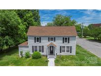 Charming two-story home featuring black shutters, light gray siding and well maintained landscaping at 315 E Washington Ave, Bessemer City, NC 28016