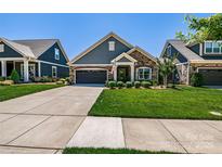 Charming home featuring stone accents, a well-manicured lawn, and an attached two-car garage at 4014 Pleasant Run Dr, Stallings, NC 28227