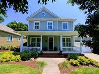 Charming two-story home with a welcoming front porch and meticulously landscaped front yard at 5424 Morris Hunt Dr, Fort Mill, SC 29708