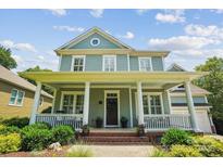 Charming two-story home with a welcoming front porch and manicured landscaping at 5424 Morris Hunt Dr, Fort Mill, SC 29708