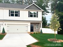 Charming two-story home featuring stone accents, a two-car garage, and a well-manicured lawn at 6712 W Sugar Creek Rd, Charlotte, NC 28269