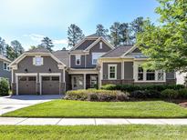 Beautifully landscaped gray home with a well-manicured lawn and attached two car garage at 705 Vintage Creek Dr, Matthews, NC 28104