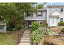 Charming townhome with brick and vinyl siding, steps leading to the front door, and lush landscaping at 7304 Pebblestone Dr, Charlotte, NC 28212