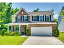 Charming two-story home featuring a brick facade, attached two-car garage, and well-manicured lawn at 7930 Kelburn Ln, Charlotte, NC 28273