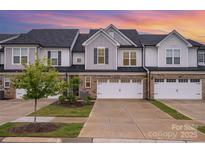 Charming townhome with brick accents, a two-car garage, and well-manicured landscaping at 9009 Odell Corners Nw Blvd, Concord, NC 28027