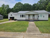 Charming single story home with manicured lawn, attached garage and sidewalk to street at 905 Klondale St, China Grove, NC 28023