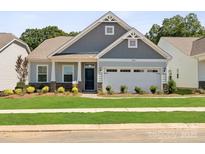 Charming single-Gathering home featuring a welcoming front porch and well-manicured lawn and two-car garage at 1029 Mapletree Ln, Indian Trail, NC 28079