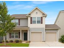 Charming two-story home featuring a two-car garage, gray siding, and beautifully landscaped front yard at 124 Canada Dr # 45, Statesville, NC 28166