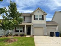 Charming two-story home with a two-car garage, manicured lawn, and a beautiful sky overhead at 124 Canada Dr # 45, Statesville, NC 28166