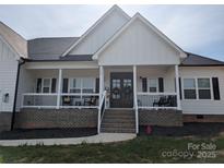 Charming modern farmhouse with a welcoming front porch and black wrought iron details at 133 Harbourtown Dr, Kings Mountain, NC 28086