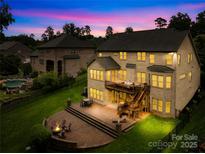 Spacious home featuring a two-tiered deck and brick patio with a fire pit, perfect for outdoor living at 2289 Pine Valley Dr, Denver, NC 28037