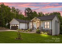 Charming home with stone accents, inviting front porch, and well-manicured lawn, all beneath a captivating twilight sky at 2577 Bonnybrook Cir, Rock Hill, SC 29732