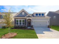 Charming home features a stone facade, gray siding, a manicured lawn, and an attached two-car garage at 3128 Spring Iris Dr, Denver, NC 28037