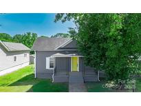 Charming home featuring a bright yellow front door, neutral siding, and well-maintained landscaping at 3209 Lowell Rd, Gastonia, NC 28054