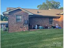Brick home exterior featuring a well-maintained lawn and covered back porch, creating a cozy outdoor space at 441 Willow Spring Ln, Rock Hill, SC 29730