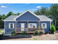 Charming blue home features a welcoming front porch, white trim, manicured landscaping, and a neatly kept yard at 5016 Old Pine Ln, Cherryville, NC 28021