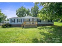 Charming single-story home with a wooden deck and well-maintained lawn at 6085 Faith Rd, Salisbury, NC 28146