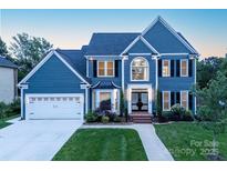 Beautiful two-story home featuring a manicured lawn, attached two-car garage and classic architectural details at 6400 Morningsong Ln, Charlotte, NC 28269