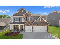 Beautiful two-story home with stone accents, a two-car garage, and manicured landscaping at 7184 Sylvan Retreat Dr, Denver, NC 28037