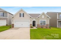 Charming single-Gathering home with a two-car garage, stone accents and well manicured lawn at 7905 Old Brook Rd, Sherrills Ford, NC 28673