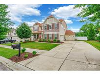 Inviting two-story home with a well-manicured lawn, charming shutters, and an attached two-car garage at 85017 Newloch Ct, Lancaster, SC 29720