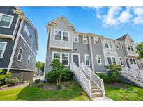 Beautiful three-story townhome with gray siding, white trim, and a welcoming front entrance with landscaped yard at 1015 Maltby St, Charlotte, NC 28217