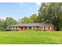 Charming one-story brick home featuring a well-manicured lawn, traditional shutters, and mature landscaping at 1081 Long Dr, Newton, NC 28658