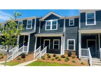 Charming two-story townhouse with blue siding, white trim, and manicured landscaping at 124 Utility Ln # E, Mooresville, NC 28117