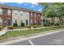 Charming townhomes featuring a mix of brick and siding exteriors, blue doors, and well-maintained landscaping at 128 Locomotive Ln, Mooresville, NC 28115