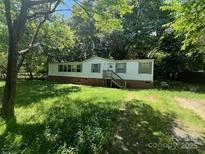 Quaint single-story home with brick foundation and front stairs surrounded by mature trees and greenery at 151 First S St # 122 & 123, Fort Mill, SC 29708