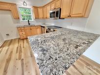Bright kitchen with stainless steel appliances, granite countertops, and natural wood cabinets at 1657 Diary Dr, Rock Hill, SC 29730