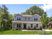 Beautiful two-story home with manicured lawn, stone accents, and a welcoming front porch at 2313 Stallings Rd, Harrisburg, NC 28075