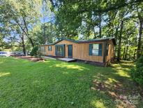 Quaint single story home featuring a well-maintained lawn with mature trees at 2461 Ridgecrest Dr, Stanley, NC 28164