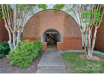 Inviting entryway featuring a unique brick archway and well-maintained landscaping at 2625 E 5Th St # F, Charlotte, NC 28204