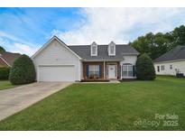 Charming single-Gathering home featuring a manicured lawn, attached garage, and inviting front porch with dormer windows at 2836 Rosemeade Dr, Monroe, NC 28110