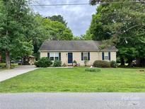 Charming single-story home with a well-manicured lawn and mature trees at 401 Yadkin St, Granite Quarry, NC 28072