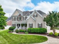 Stunning two-story home featuring stone accents, a covered front porch, and professionally landscaped yard at 538 Fairwoods Dr, Huntersville, NC 28078